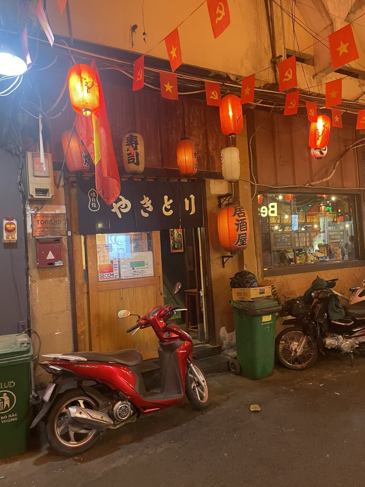 ホーチミンの通りに並ぶ赤い提灯と日本語の飲食店看板